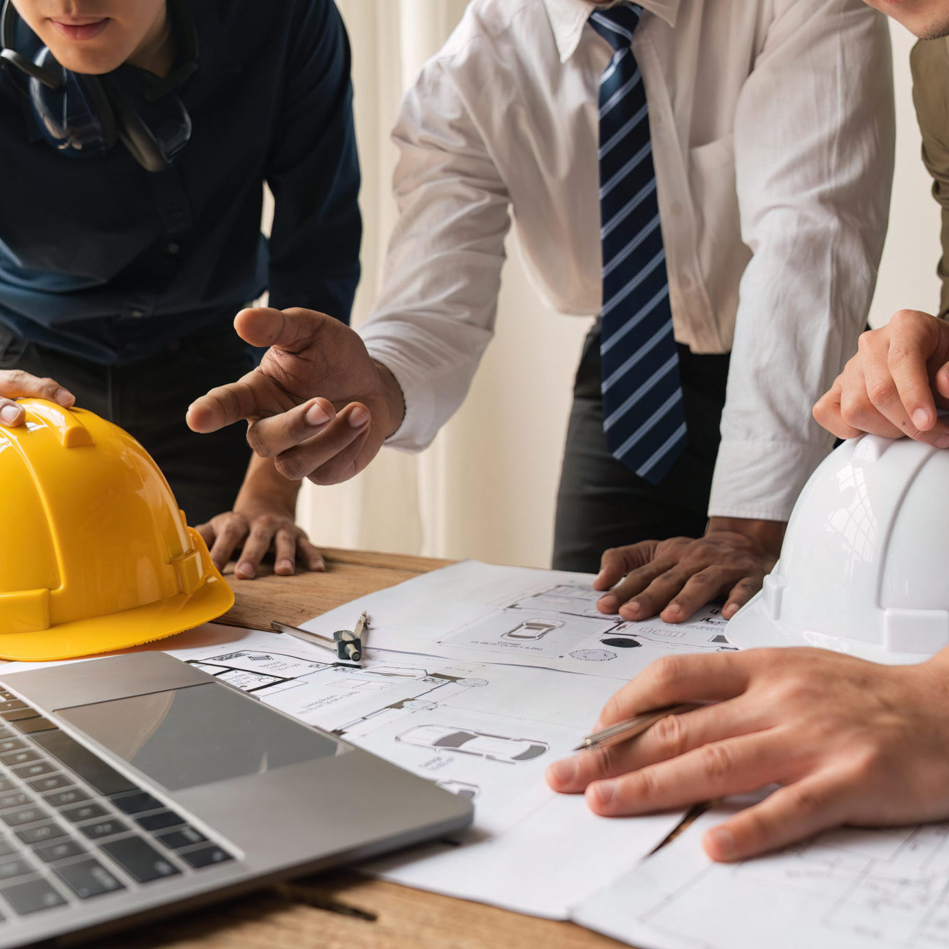 Closed up engineer meeting teamwork brain storm discussing for architectural project building construction work on blueprints.